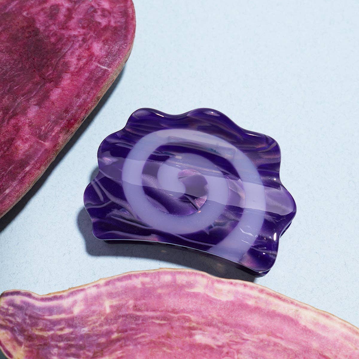 Purple decorative item with a wavy design on a light blue background