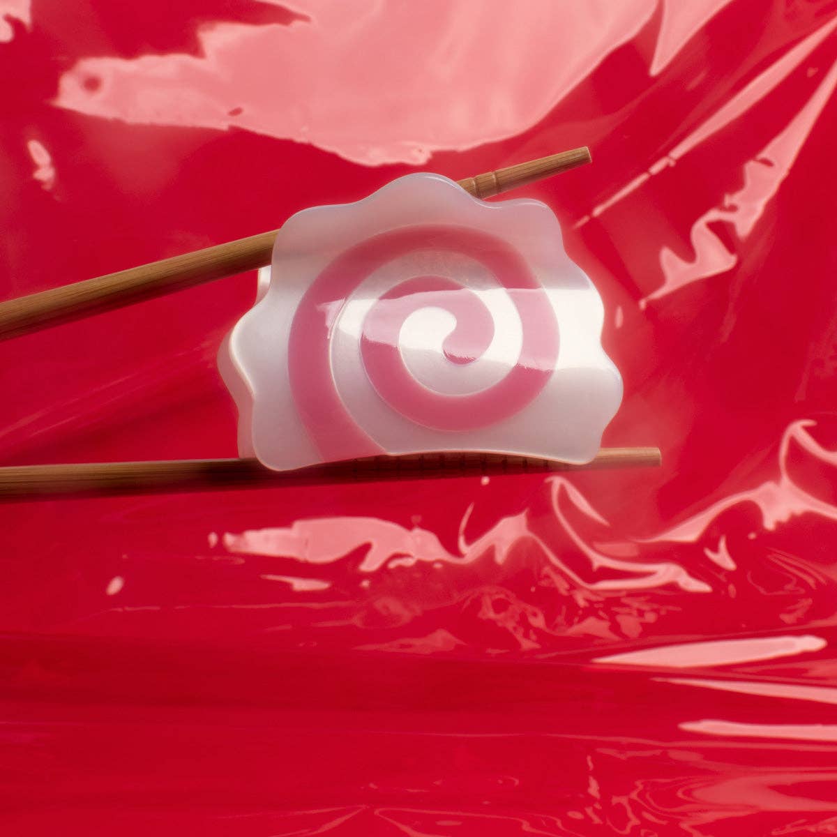 White incense holder with wooden sticks on a red background
