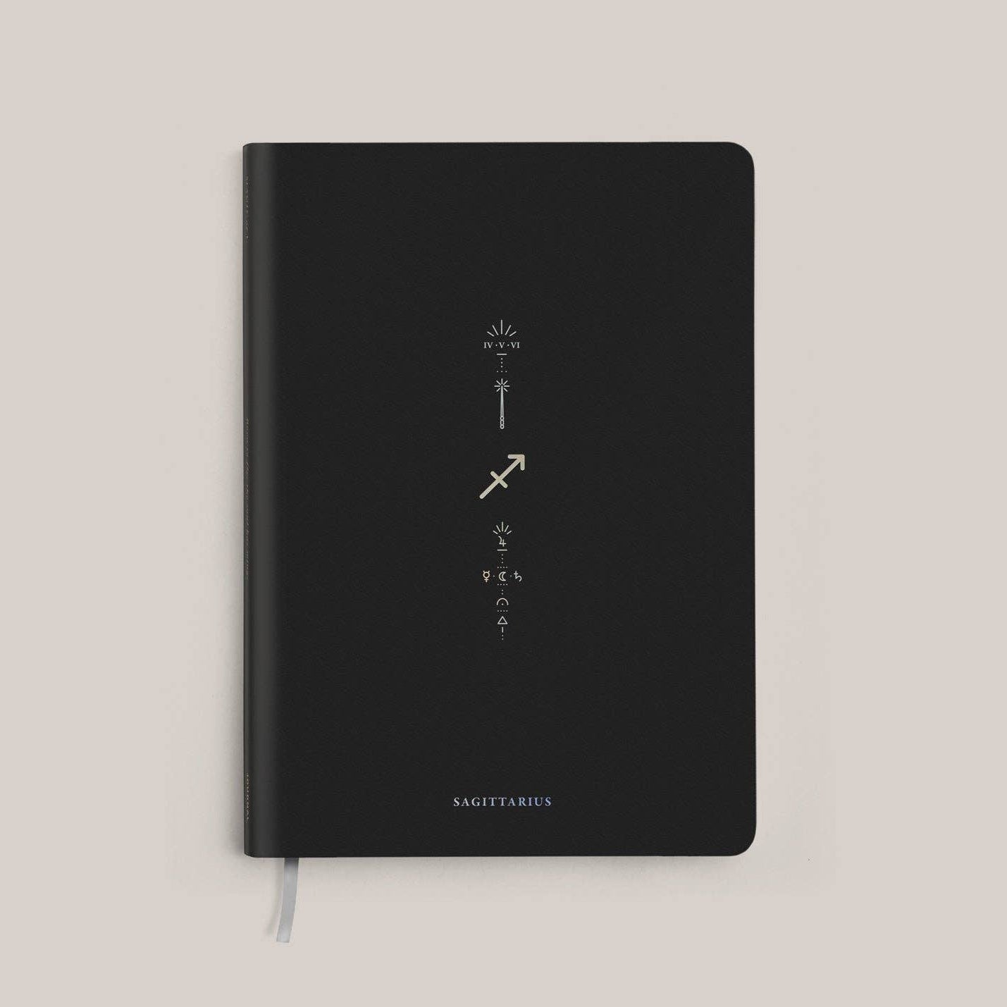 Magic of I - Zodiac Journal - Sagittarius - Black notebook with astrological symbols on a beige background