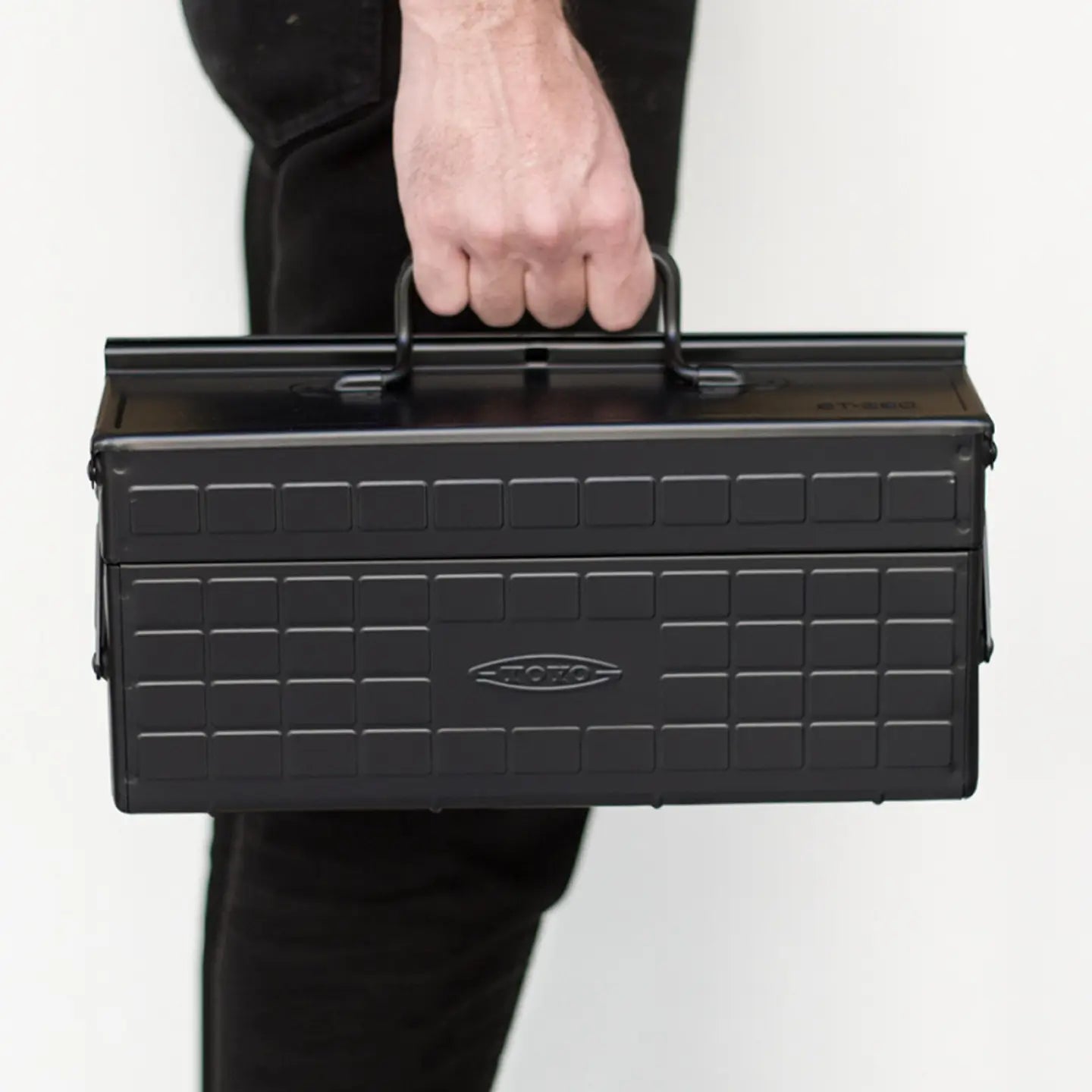Person holding a black ST-350 toolbox with a visible brand logo on a white background