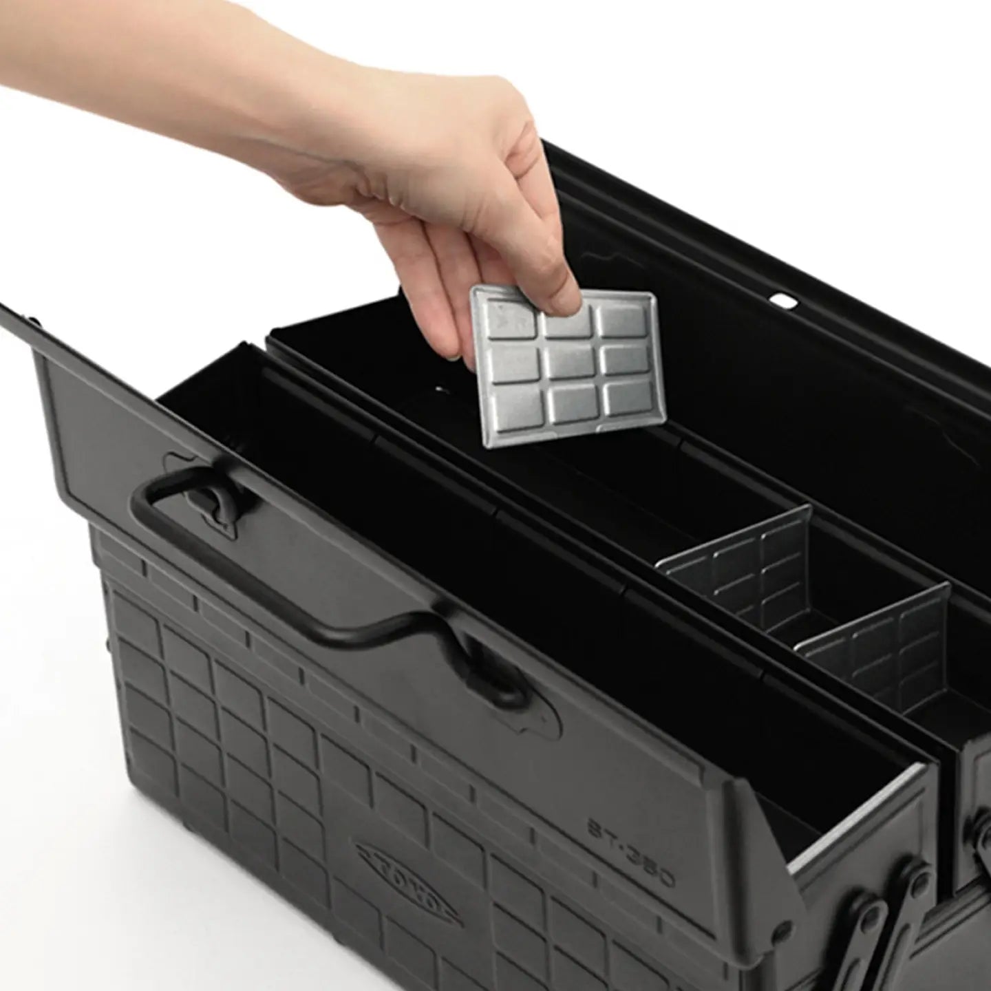 Black Toyo ST-350 toolbox with compartments and a hand placing a silver tray inside.