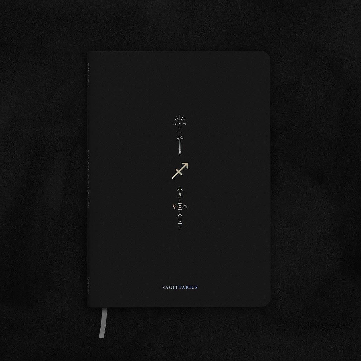 Magic of I - Zodiac Journal - Sagittarius - Black notebook with white text on a dark textured background