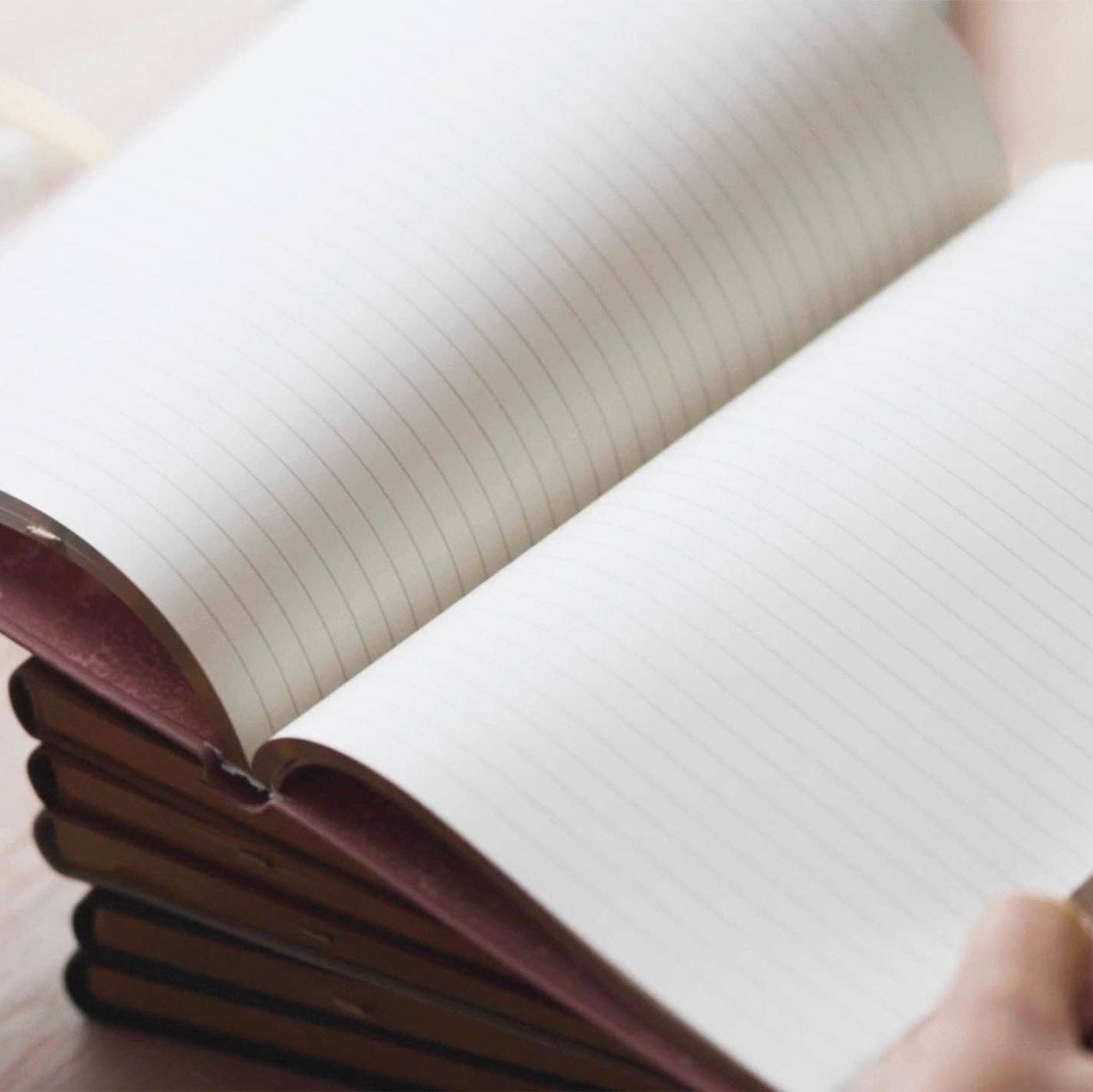 Stack of notebooks with a person holding them