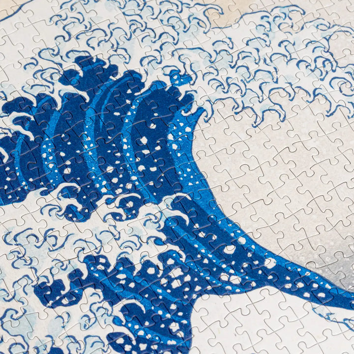 The Great Wave Off Kanagawa is a woodblock print by the Japanese ukiyo-e artist Hokusai. It is part of Hokusai’s thirty-six views of Mount Fuji series that secured his fame both in Japan and overseas. The mountain with a snow-capped peak is Mount Fuji, which in Japan is considered sacred and a symbol of national identity. Sometimes assumed to be a tsunami, the wave is more likely to be a large rogue wave. It is about to strike three boats, symbolizing the force of nature and the weakness of human being