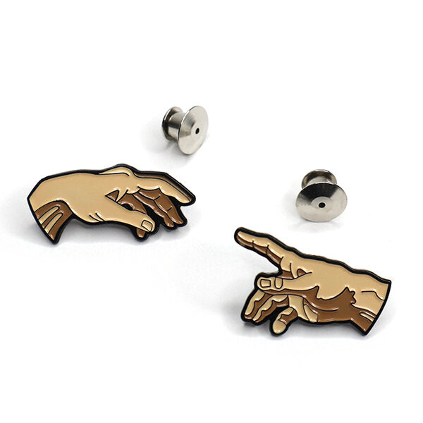 Inspired by Michelangelo’s The Creation of Adam, a set of pins for your jacket lapels, you and your best friend, or your art studio.  Details: 0.7" x 1.2" (Left)  0.8" x 1.2" (Right)  Enamel Pin Metal Locking Clasps  By Pin Museum